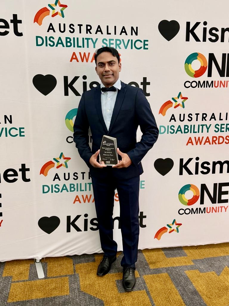 Director Dharun Madathil standing with winners award at Australian Disability Service Awards